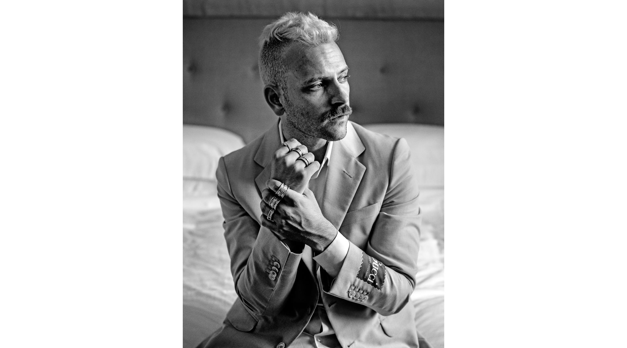 Abito in lana mohair e camicia in cotone Gucci, anello Serpenti Viper in oro rosa con pavé di diamanti, anello B.zero1 in oro rosa, anelli B.zero1 Rock in oro giallo con pavé di diamanti, tutto Bulgari.