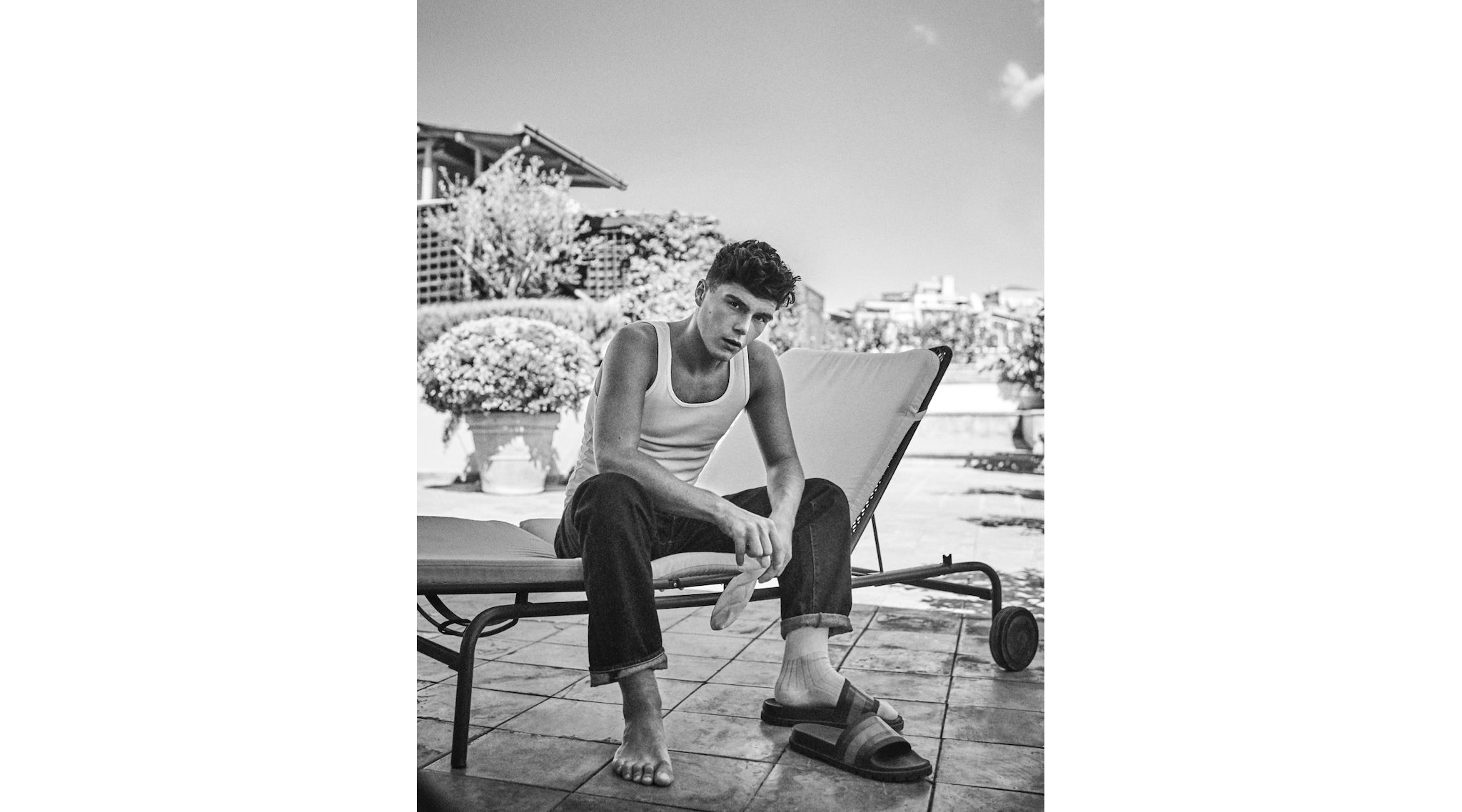 Tank top Intimissimi Uomo, jeans Levi’s, calze Gallo, sandalo slider Gucci.