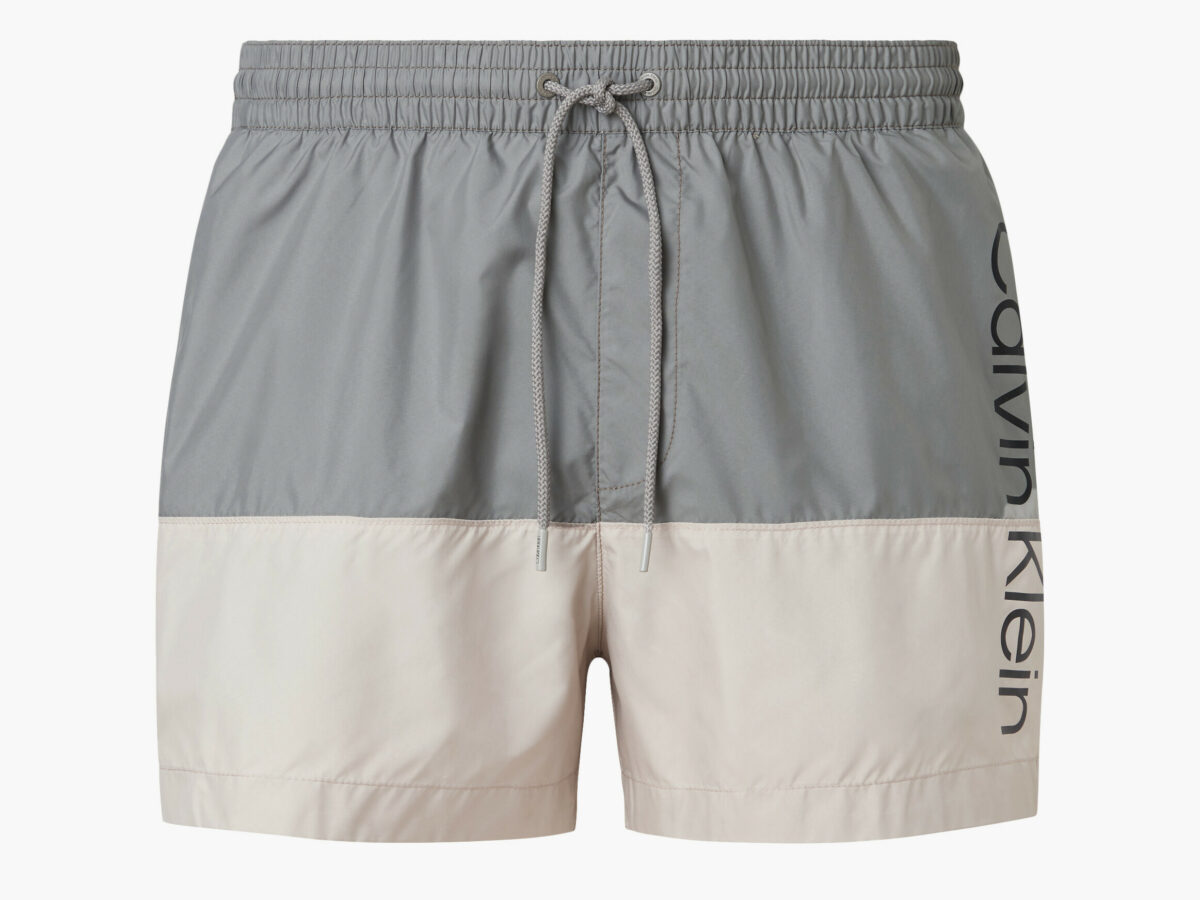 Calvin Klein pantaloncini da bagno con cordoncino corto - core logo block. Un modello bicolore strutturato con blocchi di colore tono su tono con una silhouette classica e minimale. Questi pantaloncini da bagno sono confezionati in tessuto al 100% eco-sostenibile.