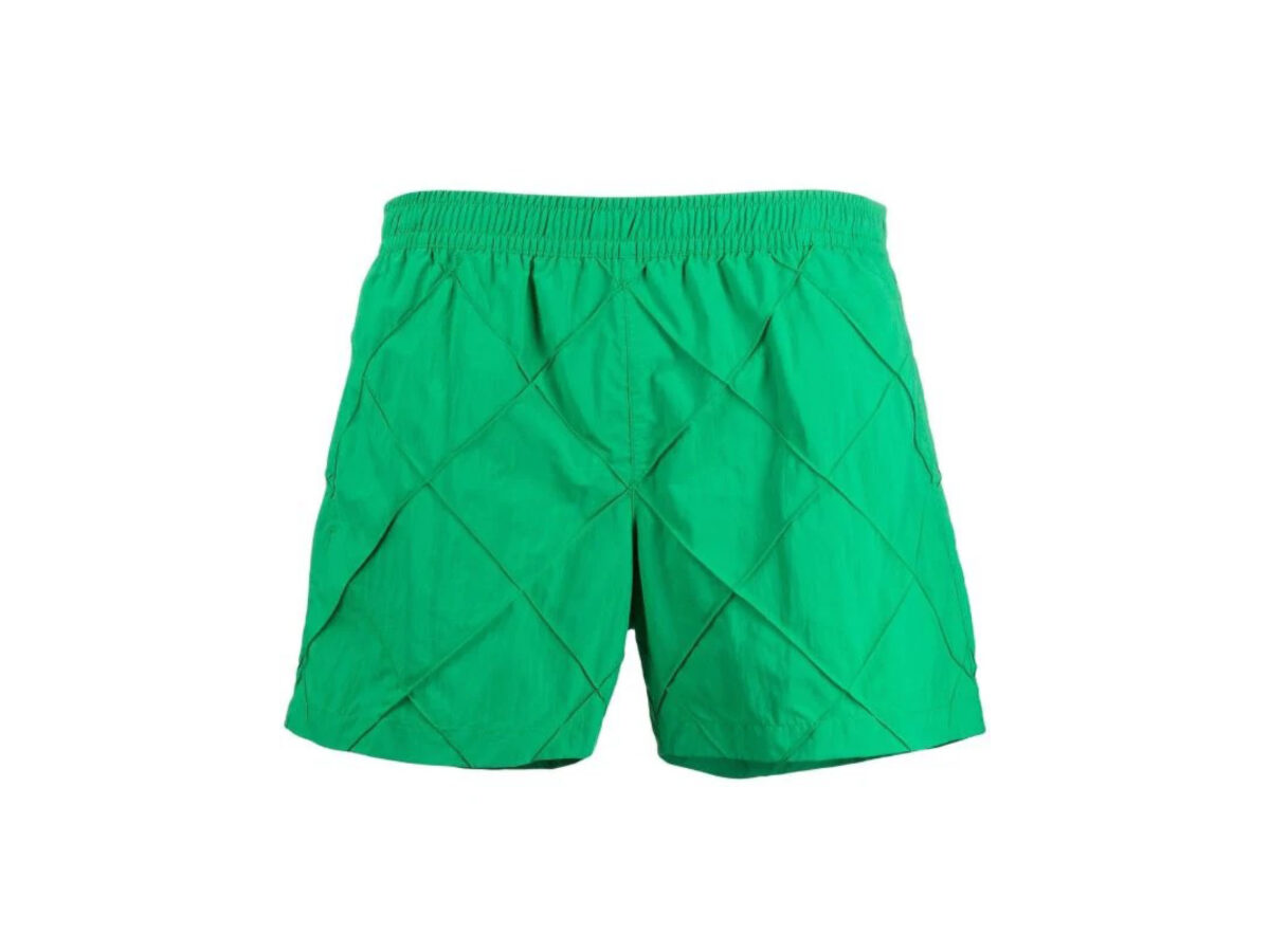 Bottega Veneta Parakeet swimwear è un costume da bagno con il colore verde brillante distintivo della maison che aggiunge una finitura vivace al paio di pantaloncini a quadri, che riprende la classica trama dell’intreccio di Bottega Veneta.