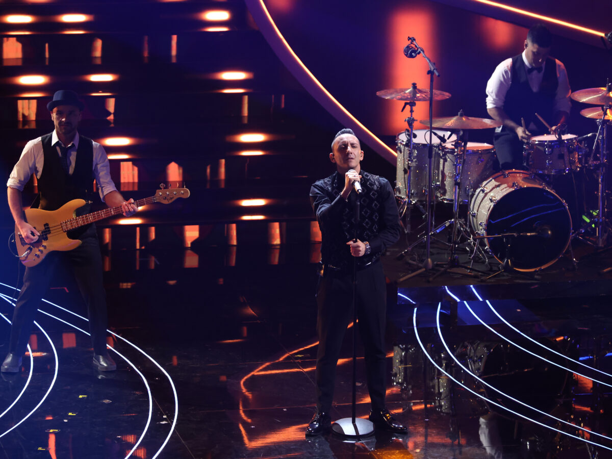 I Modà portano sul palco dell’Ariston la loro canzone “Lasciami”. Il frontman della band Kekko Silvestre dei Modà indossa un completo Emporio Armani mentre gli altri membri del gruppo il brand Demas.