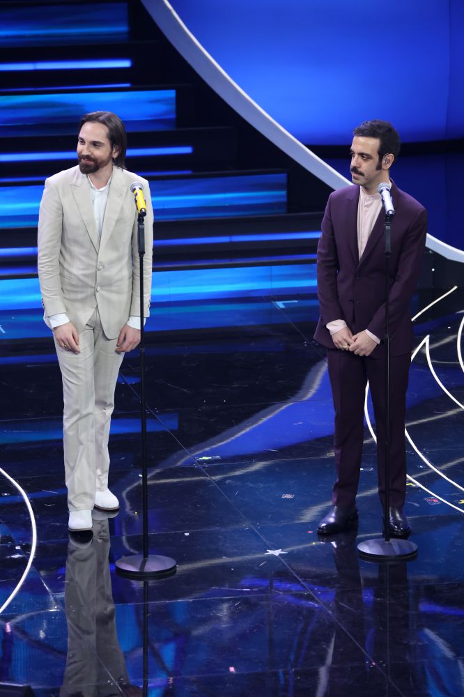 Pop ma con quel filo di irriverenza che li contraddistingue. Colapesce e Dimartino dopo il successo di “Musica Leggerissima” portano al Festival di Sanremo 2023 la canzone hit intitolata “Splash”. Indossano due look GAëLLE PARIS in contrasto: Colapesce un suit viola indossato sopra ad una camicia rosa camelia e Dimartino sui toni del pietra indossato con una camicia bianca.