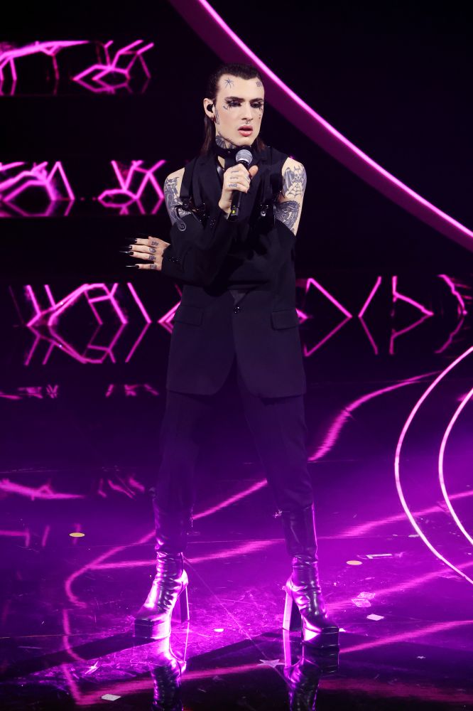 Rosa Chemical porta insieme a Rose Villain una versione duetto della canzone “America” per la quarta serata di Festival di Sanremo. Sul palco il cantante si presenta con un look Moschino progettato dal direttore creativo Jeremy Scott un blazer totalmente decostruito e riassemblato con cinghie bondage. Ciglia lunghissime, una manicure super sexy e dettagli peccaminosi. La performance non poteva che concludersi con pose erotiche tra i due cantanti.